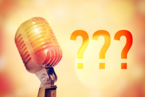 Stage microphone on a glowing abstract background with an inscription Question mark. Toned